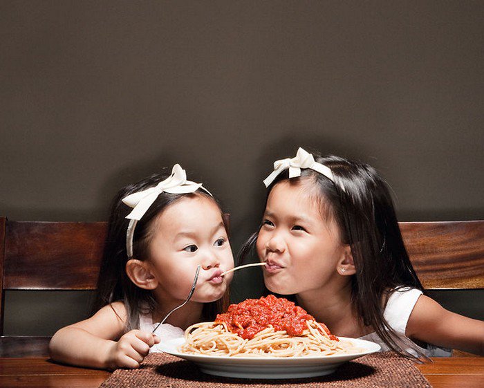 girls sharing spaghetti