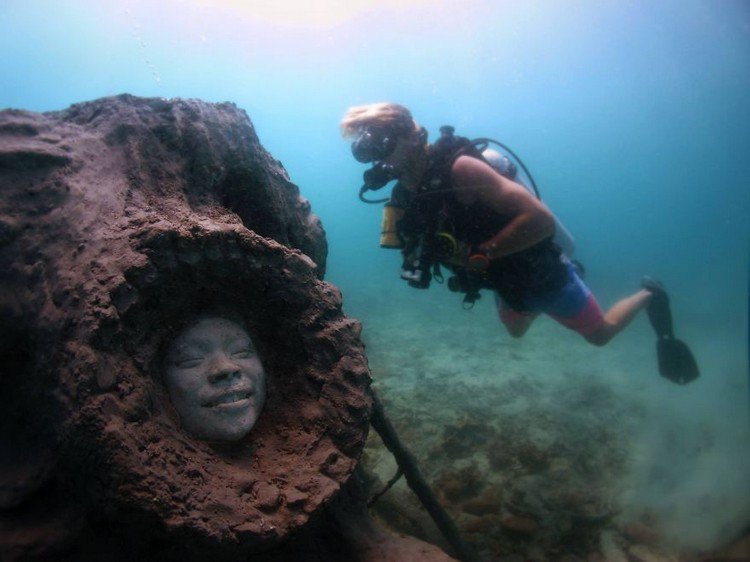 underwater sculpture smiling face diver