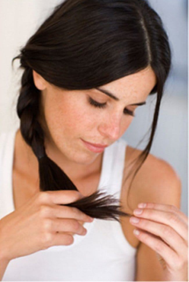 woman looking at hair ends