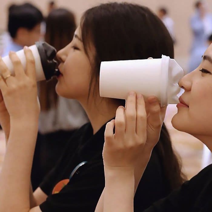 pair girls face coffee cups