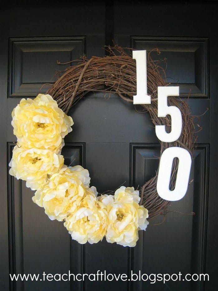 corona de puerta con flores y 150 en ella