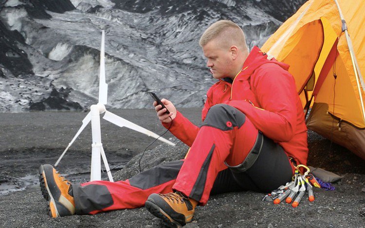 man charging phone wind turbine