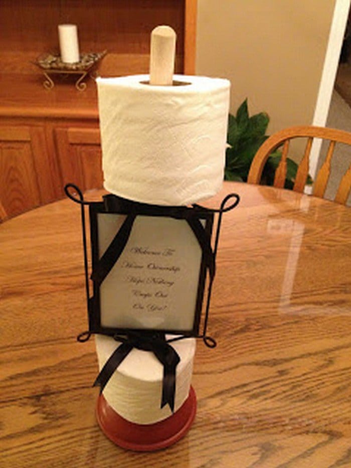 plunger with toilet rolls and photo frame attached 