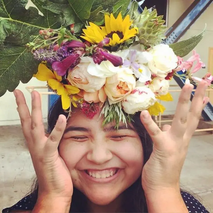woman hands up flowers on head
