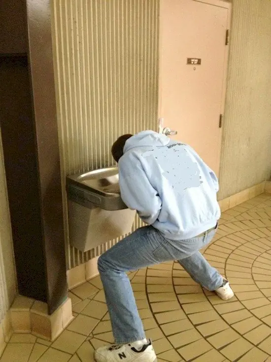 tall person drinking fountain