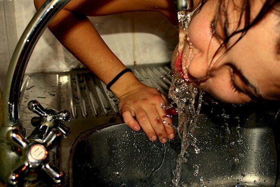 woman drinking faucet