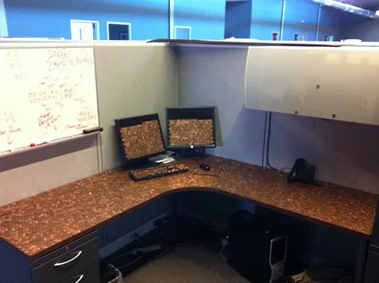 desk and computer screen and keyboard covered in pennies