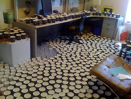 office filled with cups on floor and desk 