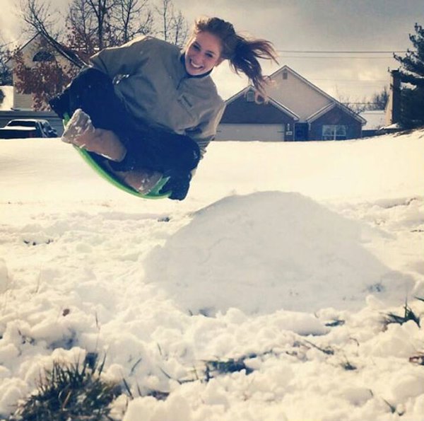 girl flying on sled