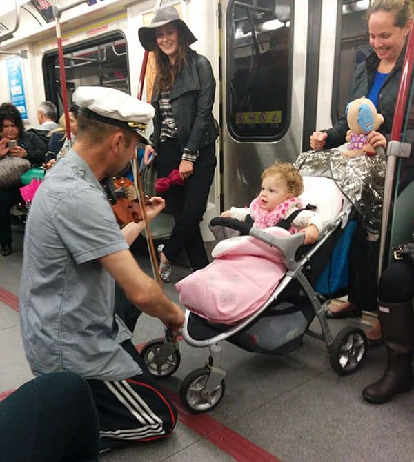 Weirdest People Ever Spotted On The Subway man playing violin to baby