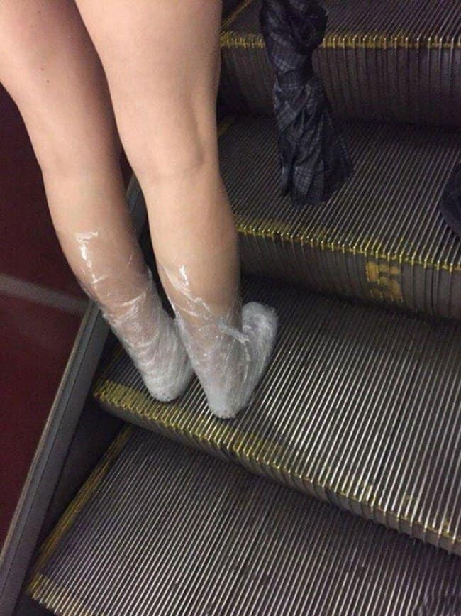 woman-in-elevator-wearing-shoes-wrapped-in-plastic