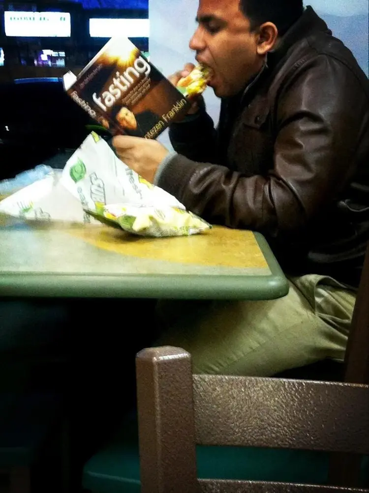 man-eating-while-reading-book-fasting-sad-people