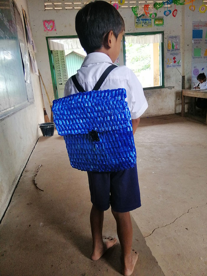 cambodian father weaves raffia strings backpack