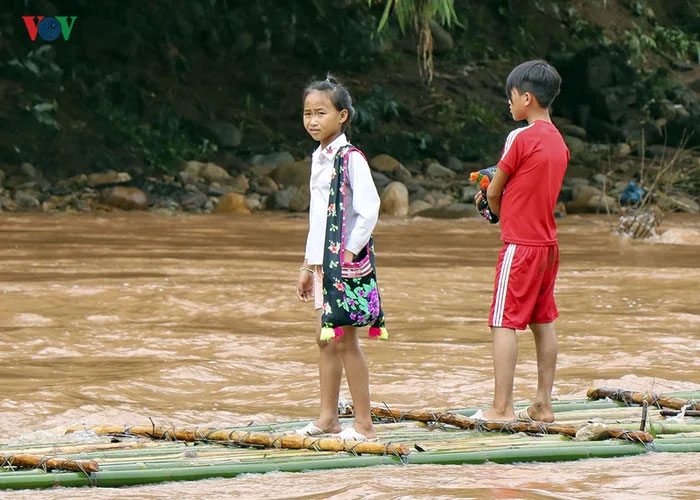 vietnamese schoolkids crossing river bamboo rafts