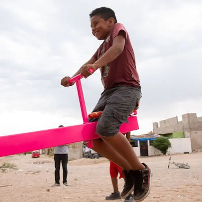 child happy seesaw in the us mexican border