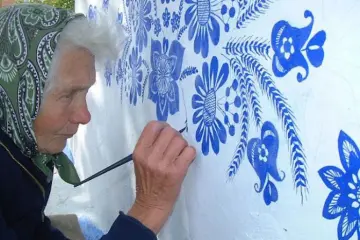 close up grandma paints houses louka