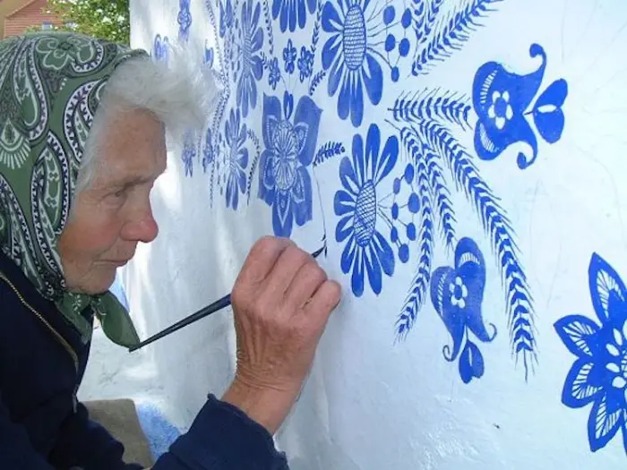 close up grandma paints houses louka