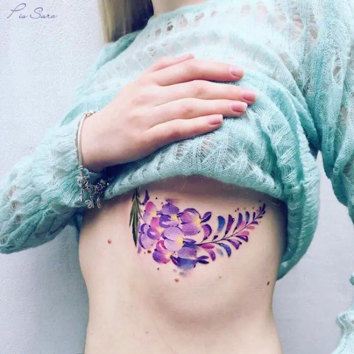 purplish flowers below breast best floral tattoo artists