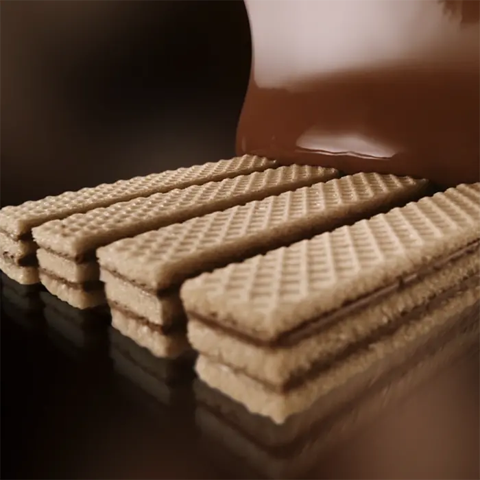 4 kit kat fingers being coated with chocolate