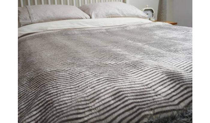 Dreamland Zebra Print Faux Fur Heated Throw Laid on Bed