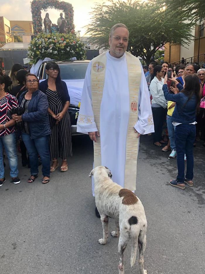 Father João Paulo Araujo Gomes with a Stray Dog at a Procession