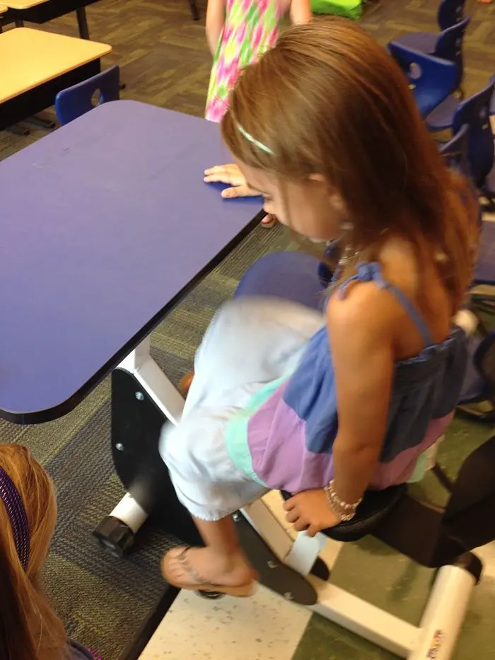 Girl Trying Out the Pedals of Her Blue Desk