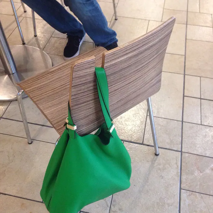 Green Shoulder Bag Hung on a Chair's Bag Holder