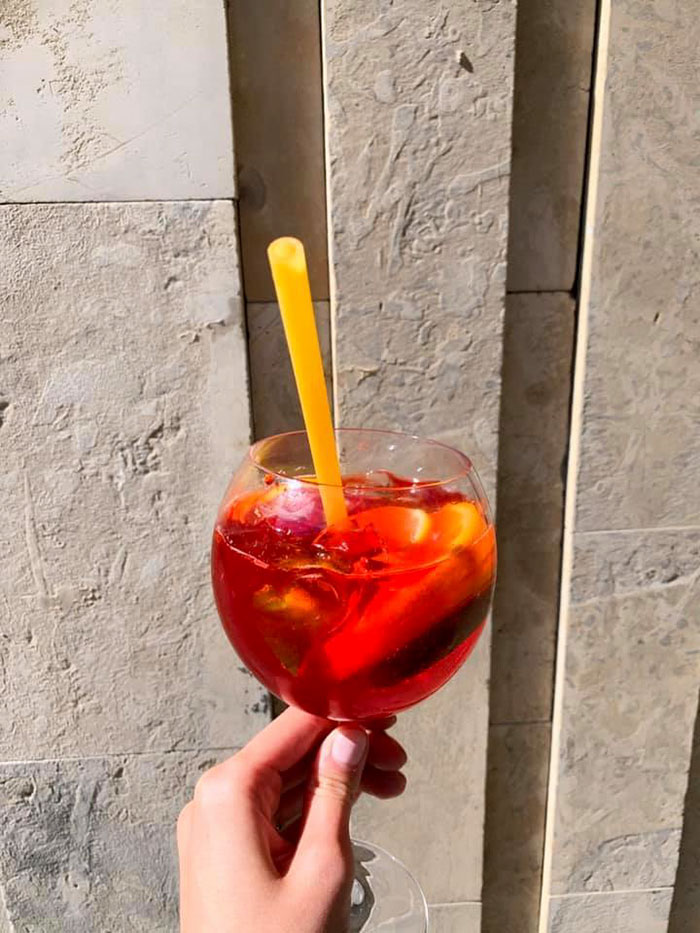 Hand Holding a Glass of Sangria with Pasta Straw