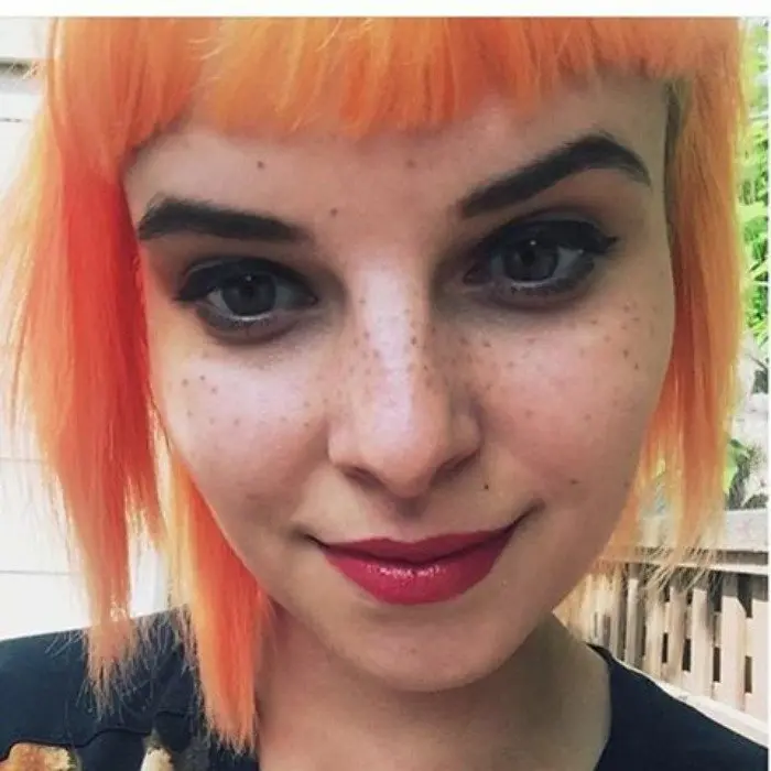 Lady with Short Orange Hair and Freckle Tattoos on Face