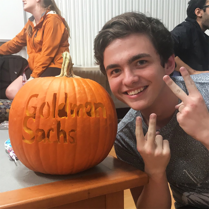 Man Posing with a Pumpkin with Goldman Sachs Carving