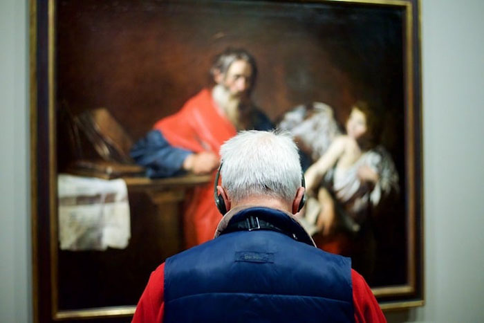 Man in Red Shirt and Blue Vest with Headphones Matching Painting