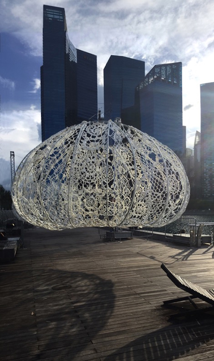 giant crochet sea urchin with skyscraper buildings in the background
