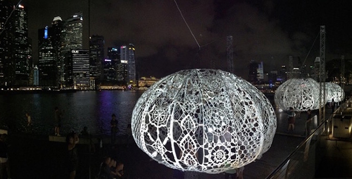 giant crochet sea urchins lit up at night