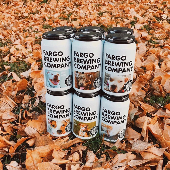 Fargo Brewing Company Beer Cans Featuring Adoptable Dogs on Autumn Leaves