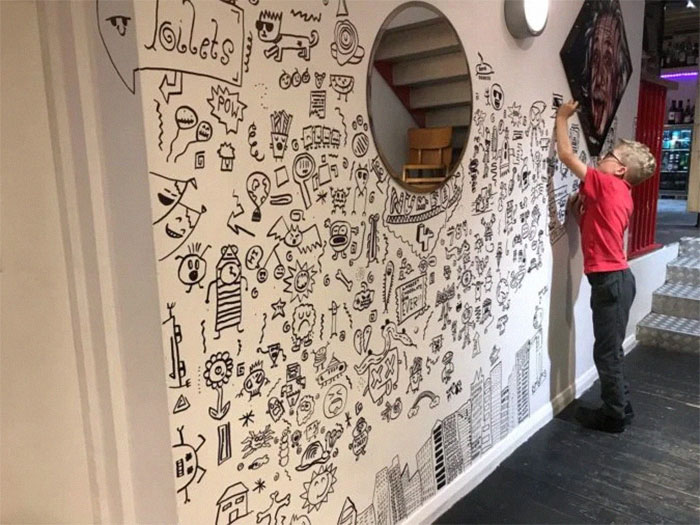 Joe Whale Doodling on a Wall with Einstein's Photo