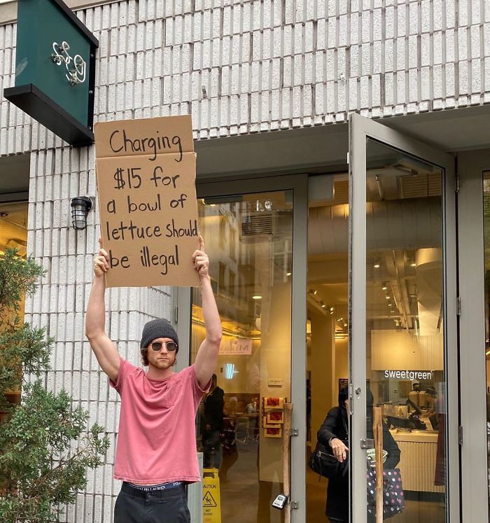 dude with sign overpriced lettuce