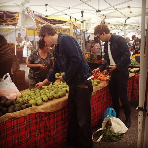 two guys choosing produce at a market