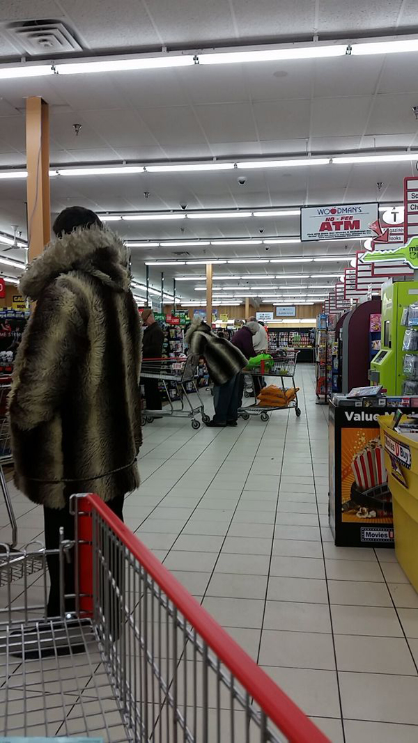 two people wearing striped fur coats at a supermarket