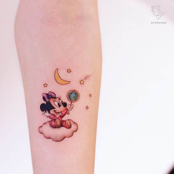 baby minnie sits on a cloud while holding an earth rattle tattoo