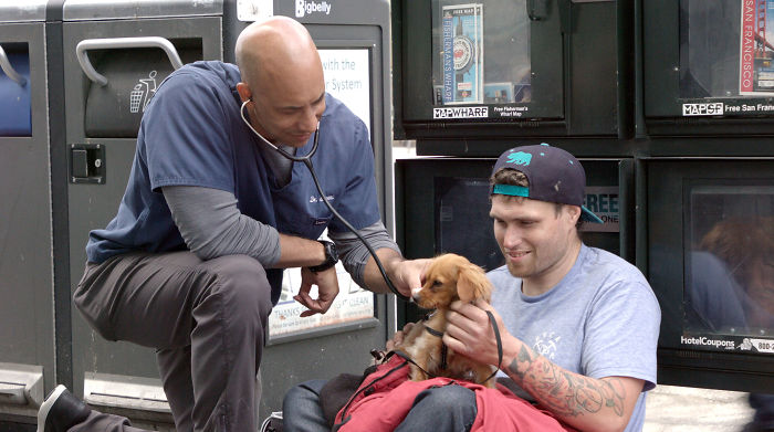 Street Veterinarian Dr. Kwane Stewart Caring for a Man's Dog