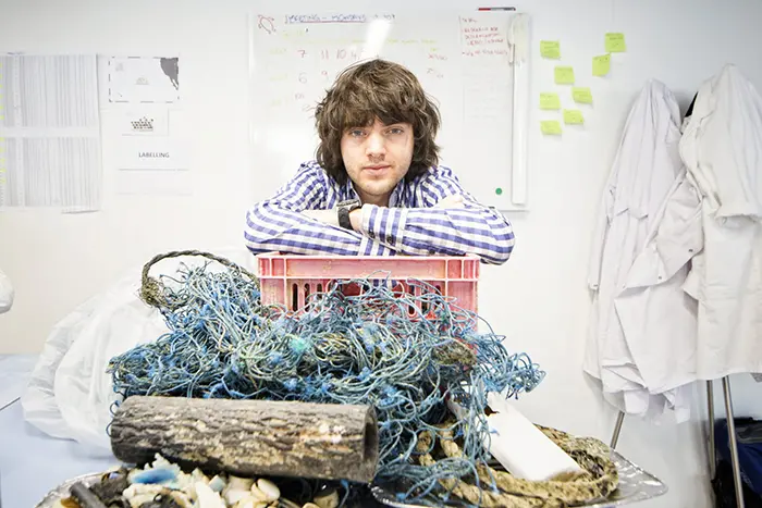 boyan slat poses with some ocean debri collected by the ocean cleanup