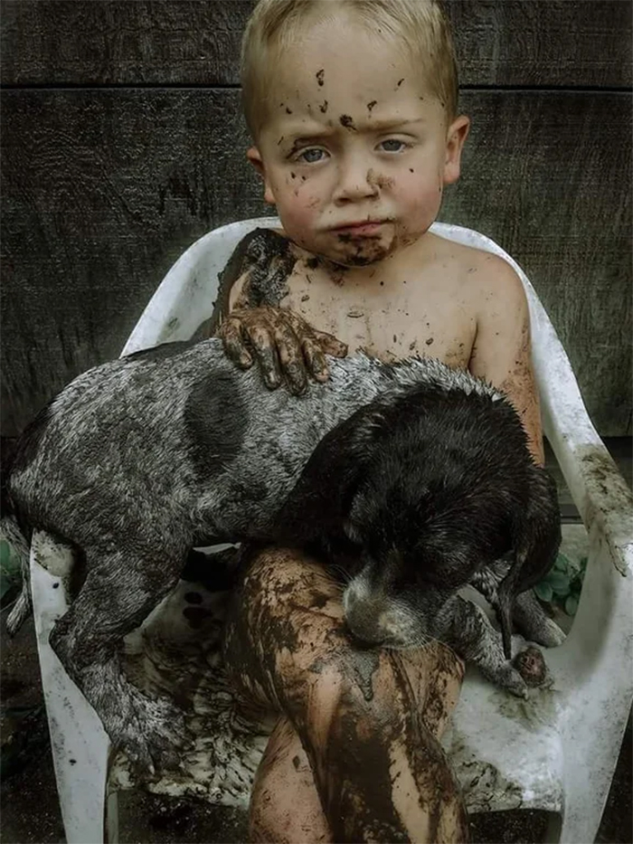 little boy and puppy mud playmates