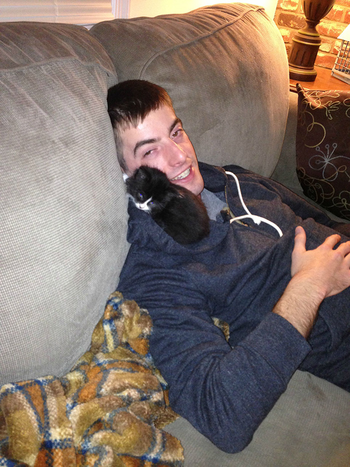 Man Sitting on Couch with Kitten on Shoulder