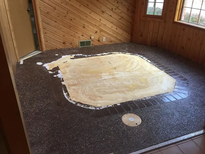 de-carpeted floor with exposed covered hidden hot tub