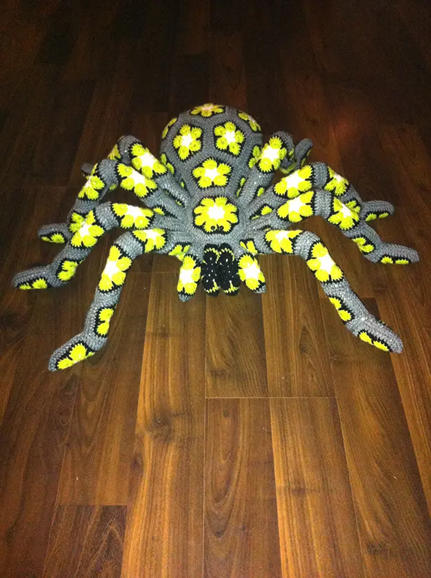 gray giant crochet spider with bright yellow flowers