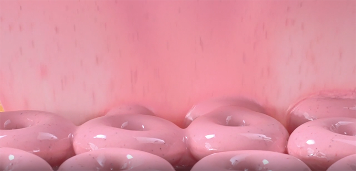 krispy kreme doughnuts passing under strawberry glaze waterfall