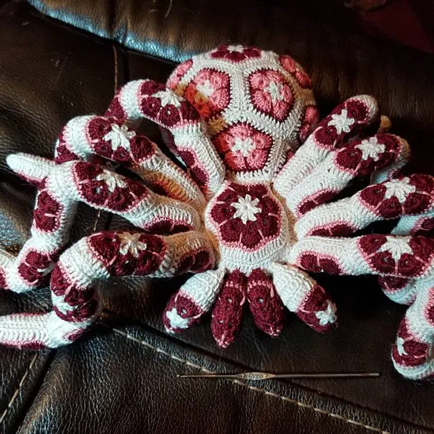 white giant crochet spider with pink and red flowers