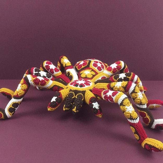 yellow giant crochet spider with a variety of colors in the details