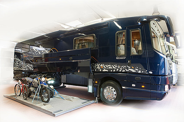 navy luxury motorhome with bikes in the built-in garage platform