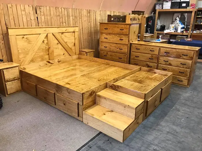 wooden king bed with dog bed extension and dressers in golden oak finish